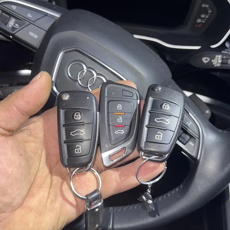 Audi Autoschlüssel kopiert und in der Hand haltend, Lenkrad im Hintergrund - Kundenauftrag