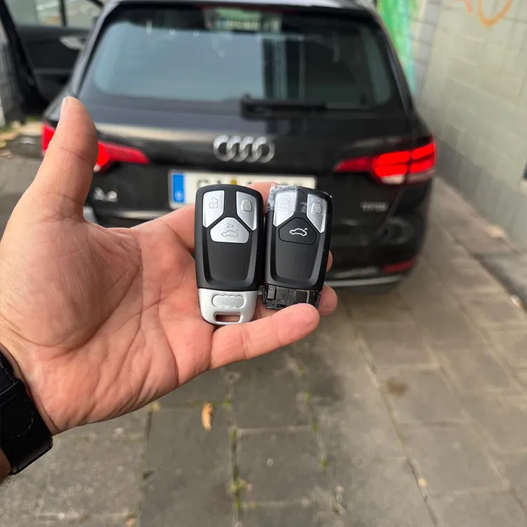 Kopierter Audi-Zweitschlüssel in der Hand, das Auto im Hintergrund - Kundenauftrag