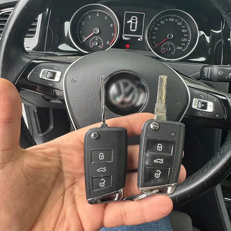 VW Autoschlüssel kopiert - Kundenprojekt - Schlüssel in der Hand, Lenkrad im Hintergrundd