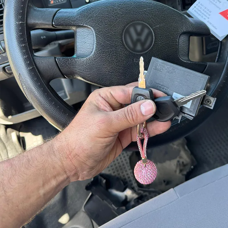 VW Zweitschlüssel angefertigt - Schlüssel in der Hand, Lenkrad im Hintergrund